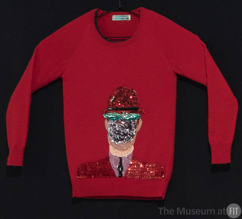 Red sweater with large center appliqué of a covered face wearing a hat in red, black, green, pu…