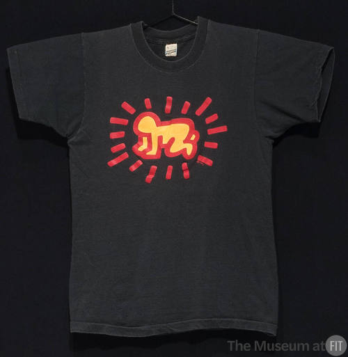 Black short sleeve t-shirt with center stylized red and yellow design of a crawling baby surrou…