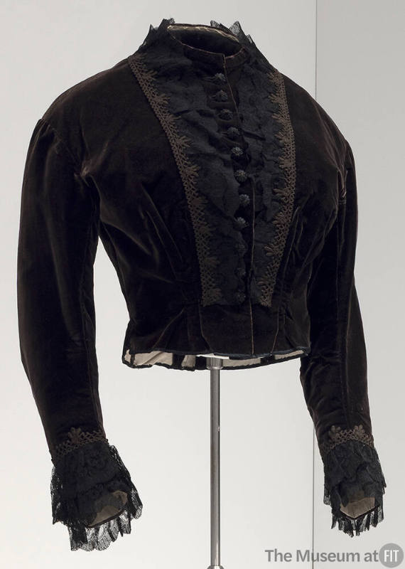 Black long sleeve dress bodice with lace and crochet trim on either side of covered button fron…