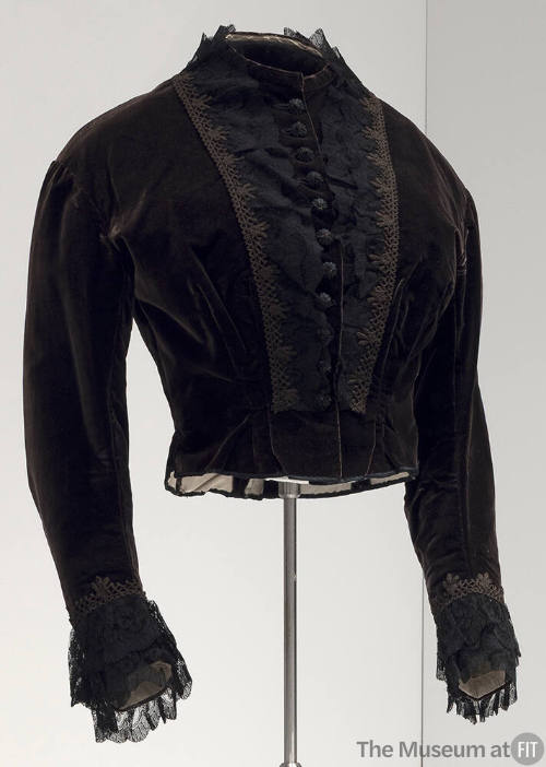 Black long sleeve dress bodice with lace and crochet trim on either side of covered button fron…