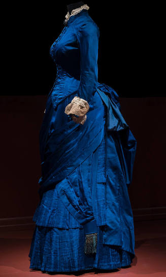 Blue two-piece floor length dress with long sleeves, beige lace trim at collar and cuffs and dr…