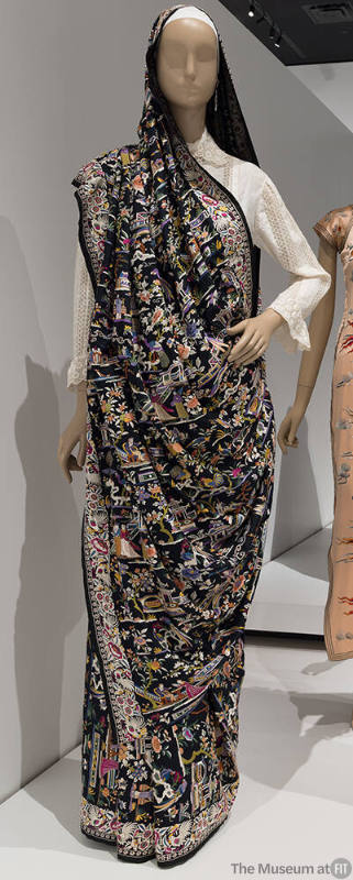 Black sari with multicolor embroidered figures, landscape and floral designs throughout over wh…