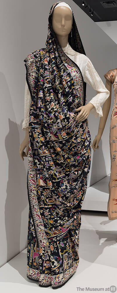 Black sari with multicolor embroidered figures, landscape and floral designs throughout over wh…