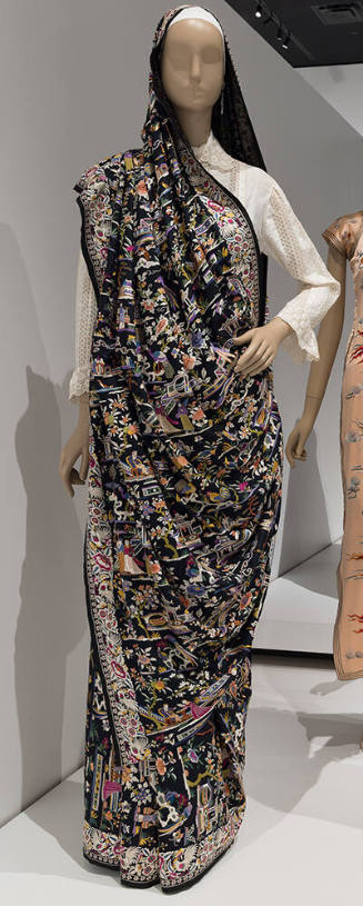 Black sari with multicolor embroidered figures, landscape and floral designs throughout over wh…