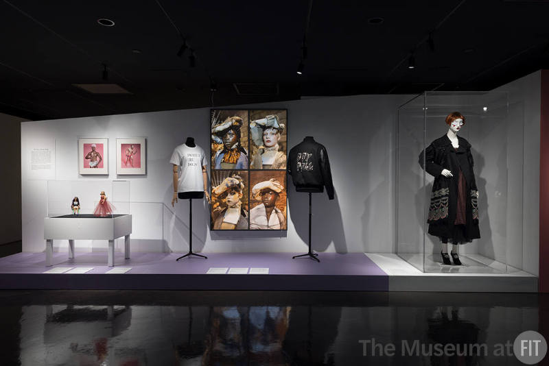 Doll Dressing exhibition installation view of three dressed mannequins, a large photograph and …