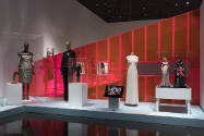Doll Dressing exhibition installation view of three dressed mannequins and four dolls in cases …