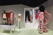 Doll Dressing exhibition installation view of four mannequins, dolls in case, and clothing hang…
