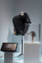 Doll Dressing exhibition installation view of a black dimensional ensemble on a dress form and …