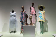 Doll Dressing exhibition installation view of four dressed mannequins and two small hats in a c…