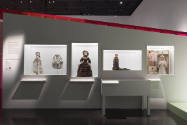 Doll Dressing exhibition installation view of four wall cases containing 18th-19th century doll…
