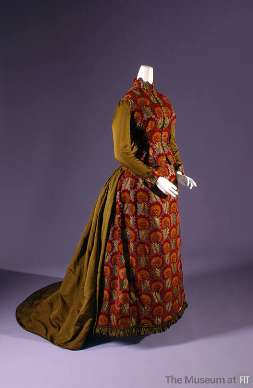 Floor length bustle dress in red and gold floral velvet with contrasting olive green silk sleev…