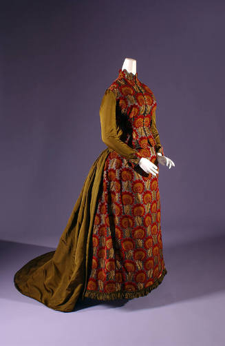 Floor length bustle dress in red and gold floral velvet with contrasting olive green silk sleev…