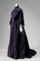 Deep purple gown with fringe and tassels, bell sleeves and floor length skirt with train