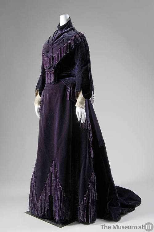 Deep purple gown with fringe and tassels, bell sleeves and floor length skirt with train