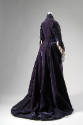 Back view of two-piece purple gown showing skirt with fringe and train