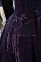 Detail view of purple gown showing back pleating and tassels