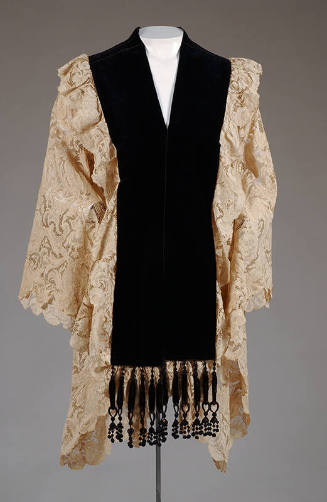 Hip length cream lace cape with wide black velvet neckline border, trimmed with black tassels