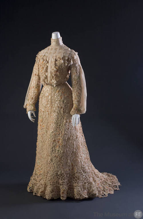 Cream floor length two-piece dress with flower shaped cutwork throughout, stand collar, long sl…