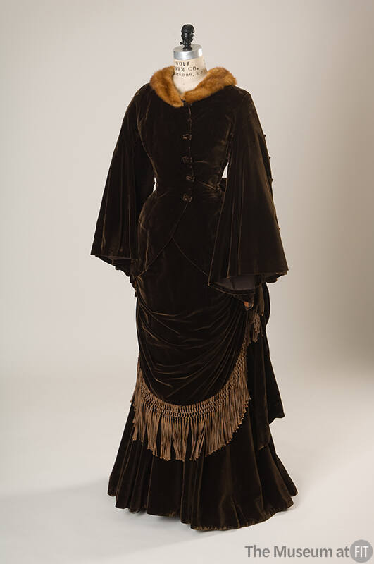 Brown velvet floor length dress with tassel trim on skirt and matching jacket with mink fur tri…