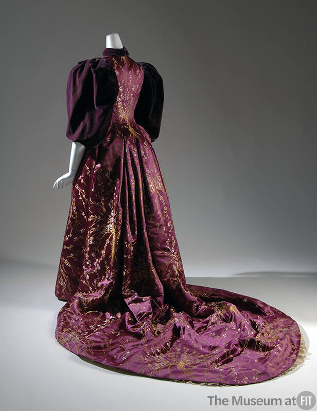 Back view of purple floor-length dress with yellow floral brocade throughout, large puffed slee…