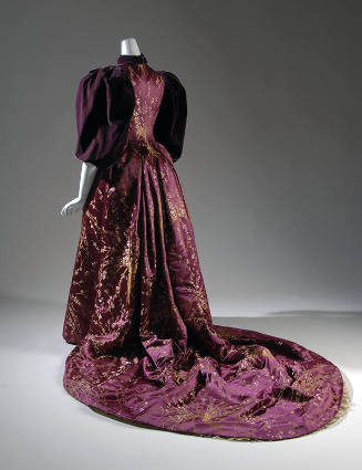 Back view of purple floor-length dress with yellow floral brocade throughout, large puffed slee…