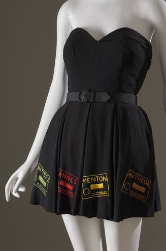 Black strapless bathing suit with belted waist and mini skirt embroidered with green, red, yell…