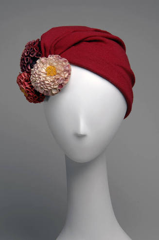 Red turban with three flowers in pink, purple and red on left side