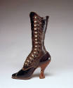 Tall black leather boot with side buttons on scalloped edge with high heel and extreme curved i…