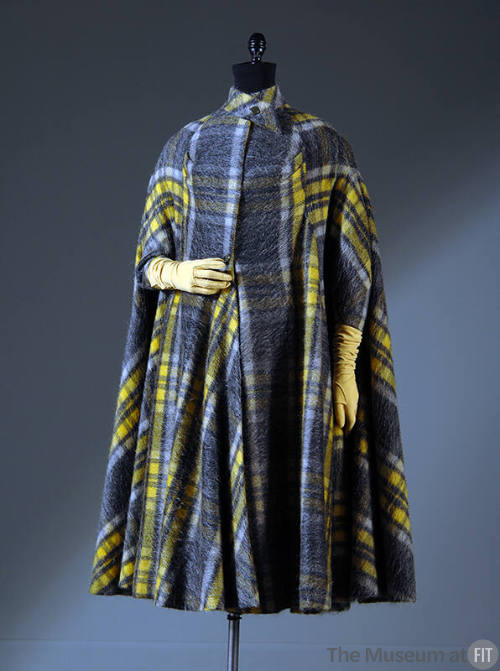 Cape coat of yellow and grey plaid with crossed and buttoned band collar and narrow sleeves