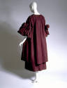 Back view of a dark purple warp coat with 3/4 sleeves puffed and with a big bow
