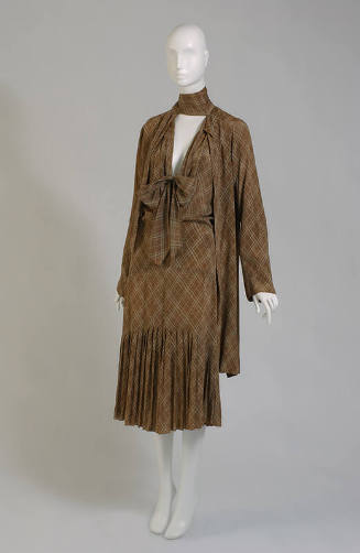 Brown plaid knee-length ensemble wth long sleeve open coat and matchingdress with pleated skirt…