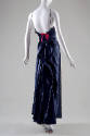 Back view of navy blue floor-length evening dress with spaghetti straps and magenta ribbon at c…