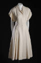 White collarless coat, short sleeves, and single button at waist