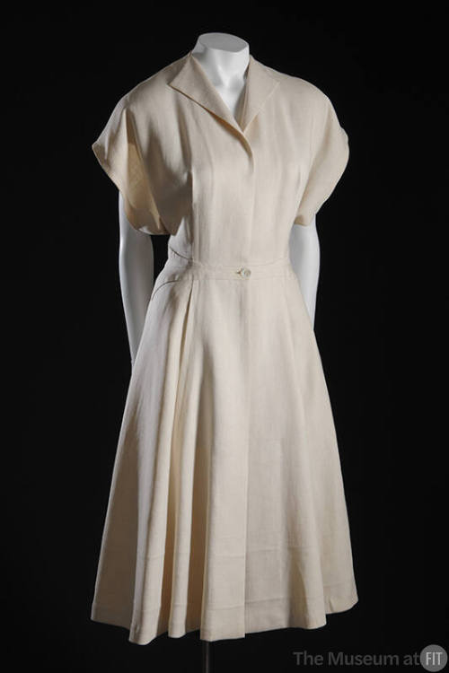 White collarless coat, short sleeves, and single button at waist