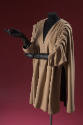 Beige short coat with deep side tucks from shoulder, 3/4 sleeves, styled with black gloves