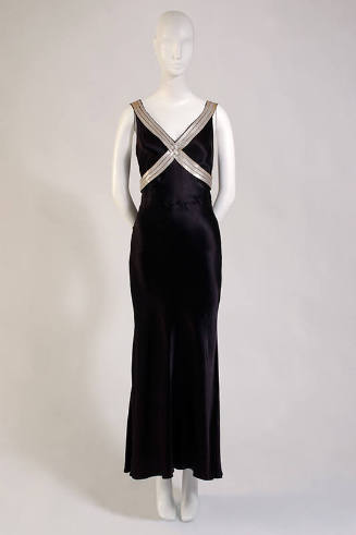 Black ankle length gown with silver leather strips crossed over bodice