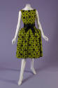 Green sleeveless evening dress with black rose pattern, black bow tied at waist and knee length…
