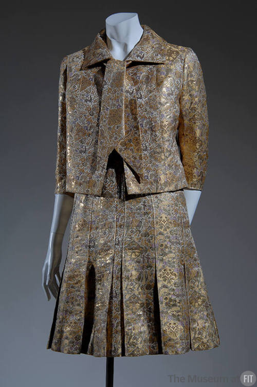Gold lame and silk brocade evening suit with ties at neckline, ¾ sleeves and pleated mid thigh …