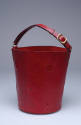 Red leather bucket shaped handbag with cut-out circles
