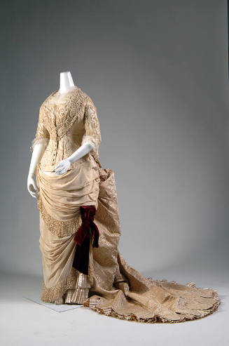 Pale gold and cream evening dress, elbow length sleeves, bodice, and floor length bustle skirt …