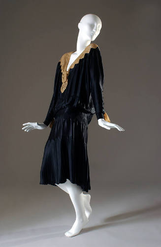 Black evening dress with lace neckline and wrist trim, pleated skirt
