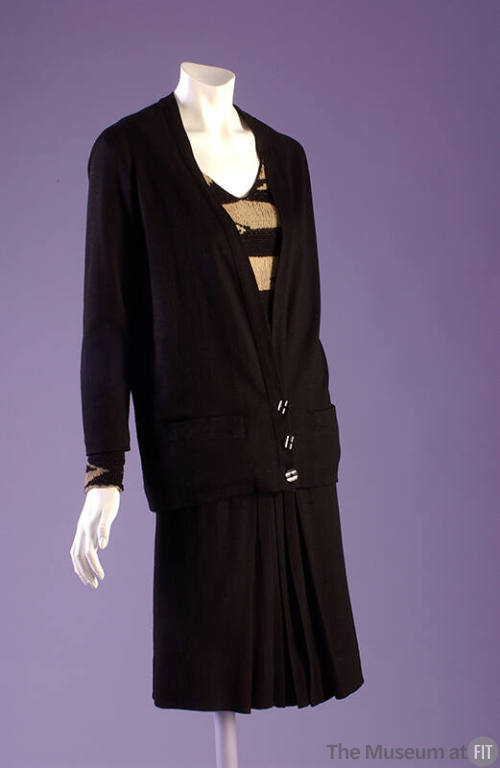 Black suit with cardigan jacket, tunic sweater with black and tan stripes, black skirt