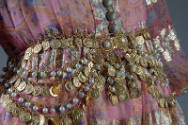 Gold metal chain belt attached to pink dress with faux pearls and coins