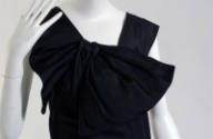 Sleeveless floor length black evening tress, draped bow at right shoulder
