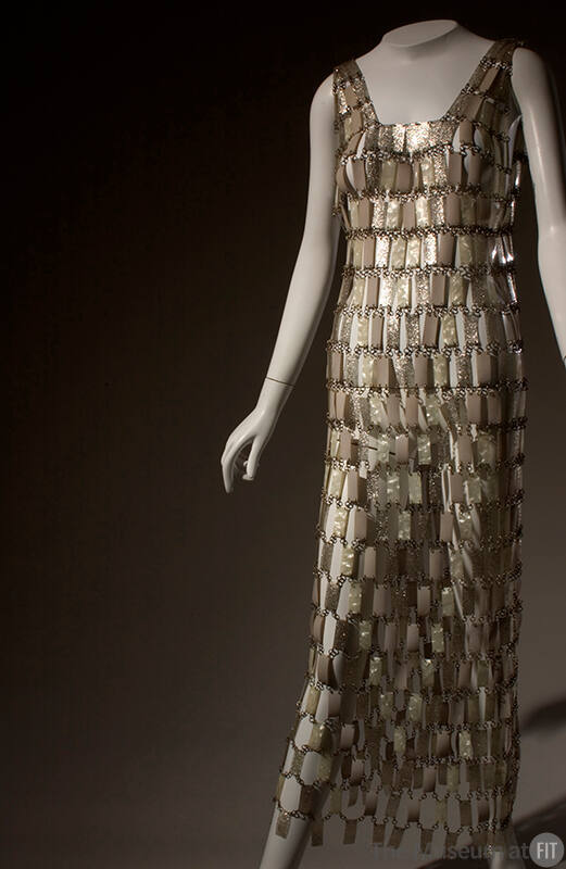 Long, sleeveless chain mail dress of pearlescent and silver plastic rectangles linked by metal …