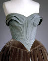 Detail view of blue evening dress showing boned bodice with pleating at neckline and pointed fr…
