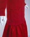 Detail view of bottom of red cardigan with large square patch pocket and gathered red skirt