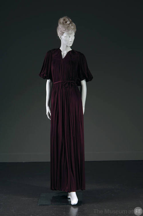 Purple floor length evening gown with intricately shirred shoulder yoke, high V-neck, elbow len…