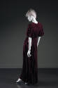 Back view of purple gown showing shirred shoulder yoke and pleating extending to floor