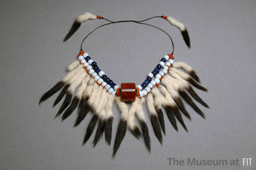 Blue and white beaded necklace with hanging fur tails on brown cord